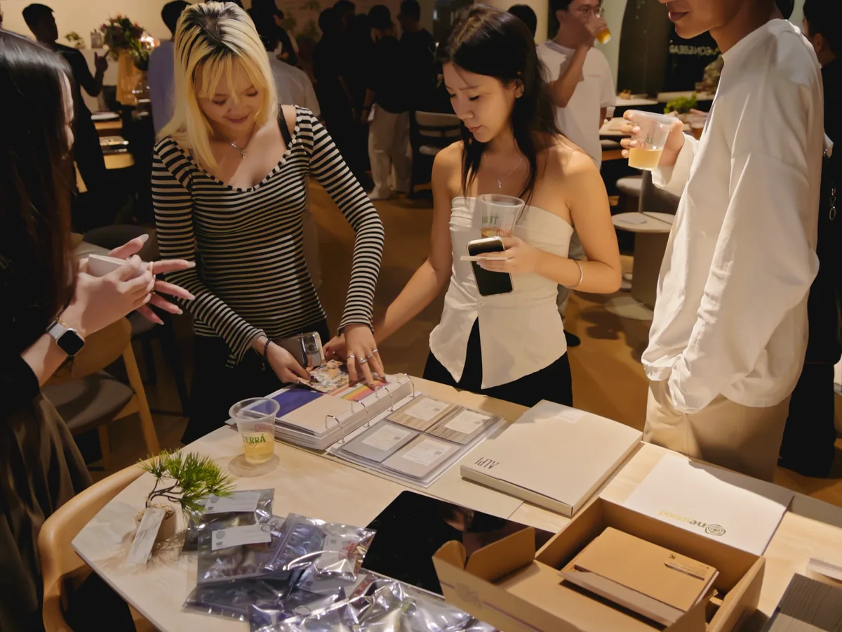 Printed collateral and material samples laid out on a table, being reviewed