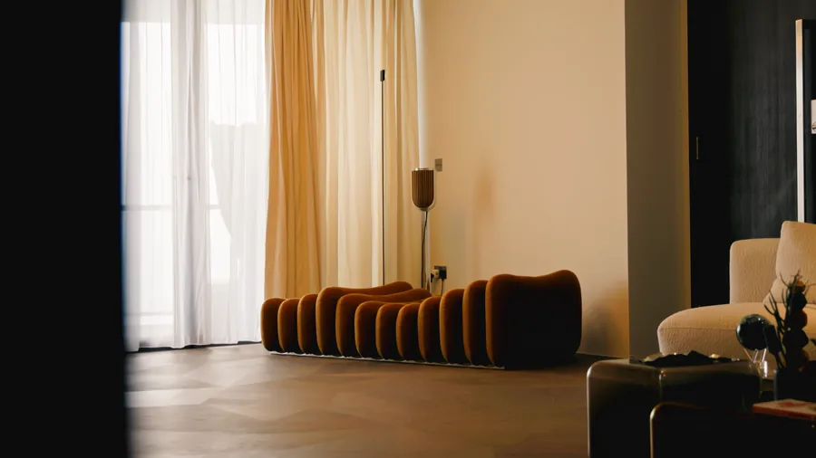 Living room with a curved rust velvet sofa