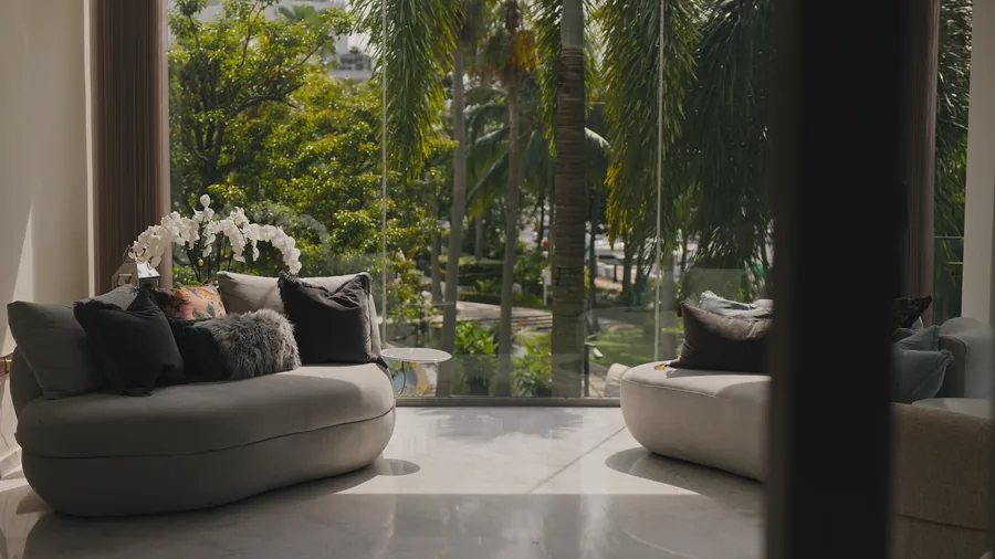Living room opening onto mature greenery
